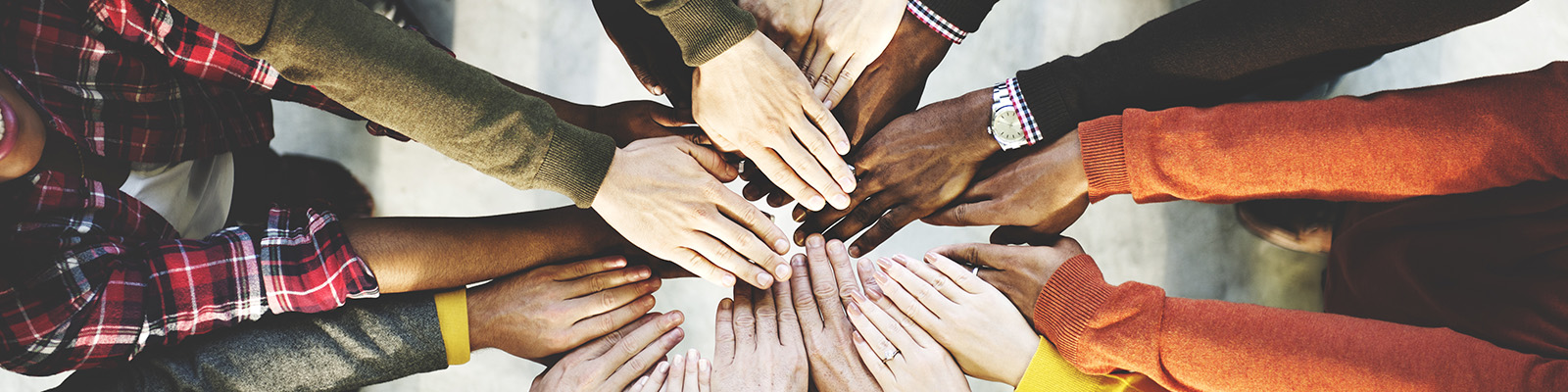 group of people with hands in the middle stacked on top of each other